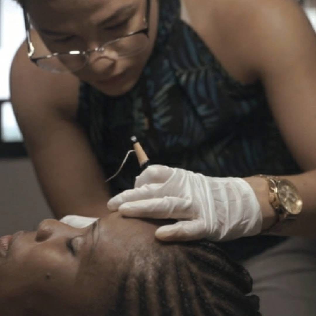 Amii applying microblading strokes to a client